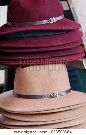 Close-up of stack of fashion female wool hats purple and beige colors.
