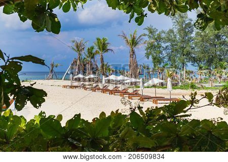 White sand beach with wooden deck chairs and white umbrella around sunrise beach at Lipe island Andaman Sea Thailand