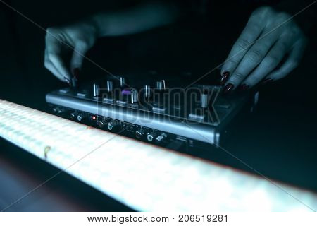DJ mixer disco illuminated by floodlights at the club