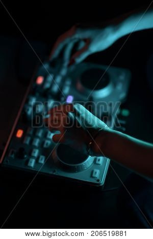 DJ mixer disco illuminated by floodlights at the club