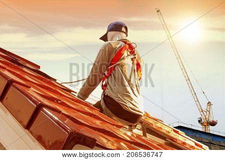 Roof repair men model worker replacing tiles on the roof house with sunlight background