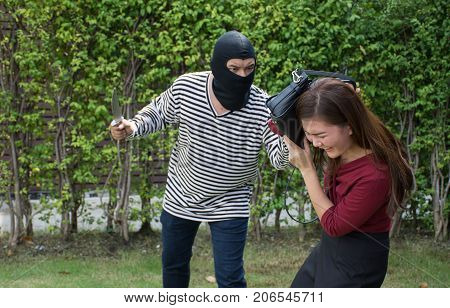 Male robber run into robbing a handbag/Threatening with knife to scared Asian woman,criminal concept/Selective focus