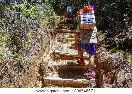 Ranau,Sabah-March13,2016:Mountain porter carrying a heavy backpack to Laban Rata of the majestic Mount Kinabalu in Ranau,Sabah Borneo,Malaysia.