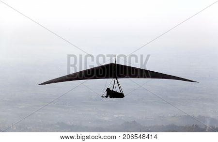 Silhouette Of A Man Flying High With His Hang Glider