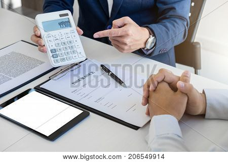 Businessman being analysis and making the decision a car insurance policy Agent man is using calculator to presentation detail and waiting for his reply to finish.