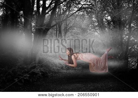 Full length of woman levitating  against way between trees