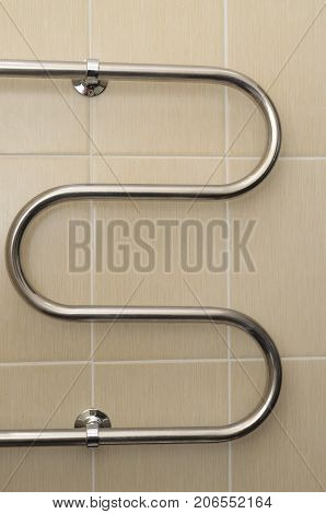 Metal curved coil in the bathroom with ceramic tiles