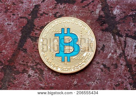 Close up of Golden cryptocurrency blue bitcoin on red background. High resolution photo.