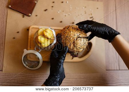 A top view of a fresh juicy meat burger and rustic potatoes on a wooden cutting desk. Fast food composition on a wooden table background, close-up. American burger. Cooking, fast food, concept.