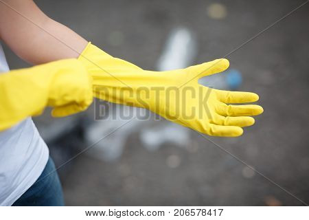 Outdoors cleaning. Environmental protection. Closeup cropped portrait. Getting started cleaning. Yellow rubber cleaning gloves closeup. Workhouse concept. Homework, washing and cleaning of the theme.