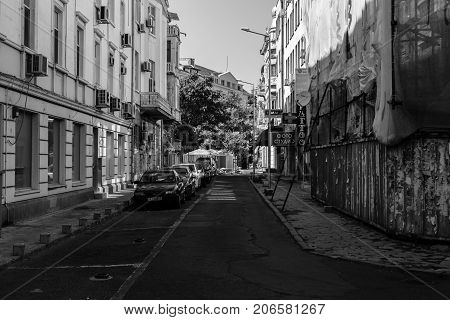 BURGAS BULGARIA - AUGUST 20 2017: The central streets of the seaside city. Black and white. Typical architecture new and dilapidated buildings nearby.