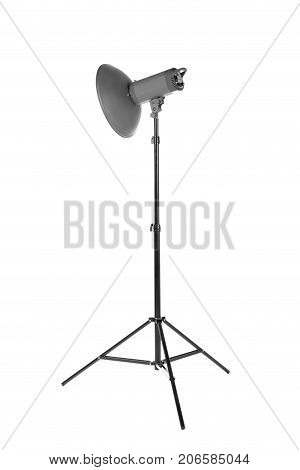 Professional photo studio flashlight isolated over the white background. Photographic light on a long tripod. A reflector and outbreak on a tripod. Dark black photo equipment.