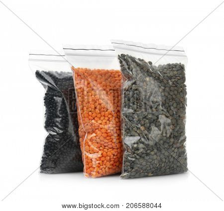 Different types of lentils in  bags on white background