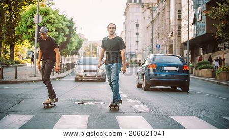 Two Pro Skateboard Rider Ride Skate Through Cars On Street