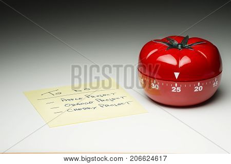 Tomato-shaped kitchen timer set at 25 minutes to fight procrastination in studying and working.