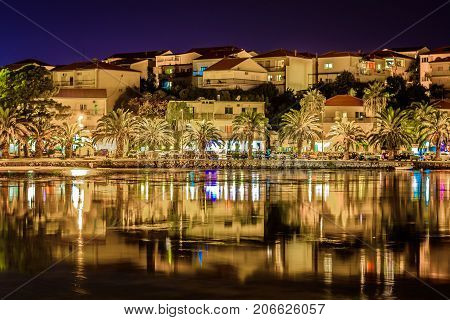 Night waterfront view at small town in suburb of town Split, Stobrec townscape, Croatia.