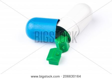 Three Small Green Houses Are Coming Out From Big Blue And White Capsule Looking Like A Big Pill