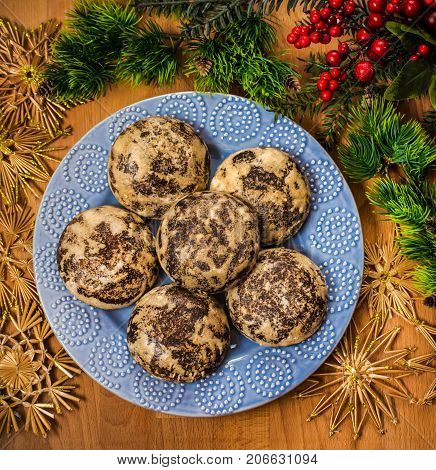 Christmas cookies with festive decoration. Plate with tasty New Year homemade sweets on wooden table. Gingerbread and christmas cookies with festive decor on wooden background.