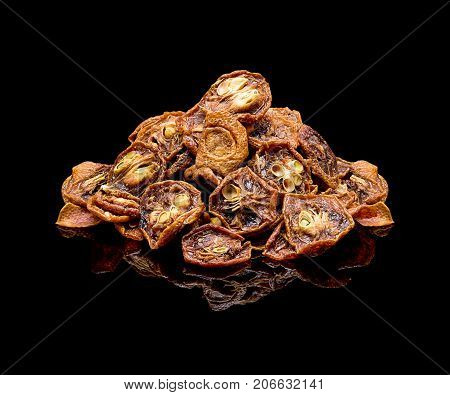 Slices of dried fruit kumquat. Chinese tea additive for brewing. On a black glossy background with real reflection. Flower tea