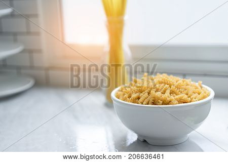Macaroni in bowl with spaghetti sticks nooddle dinner food restaurant in kitchen room at home modern and mirror