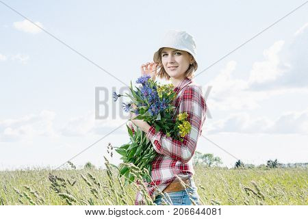Girl With A Basket Of Flowers In The Field.