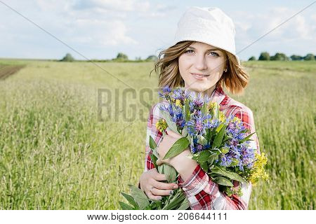 Girl With A Basket Of Flowers In The Field.