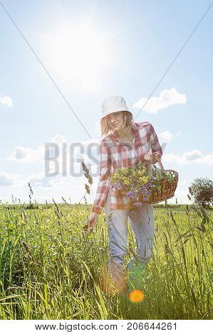 Girl With A Basket Of Flowers In The Field.
