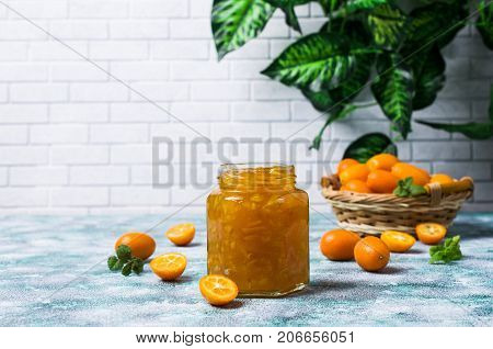 Jam from kumquat with rind in glass on a wooden background. Selective focus.