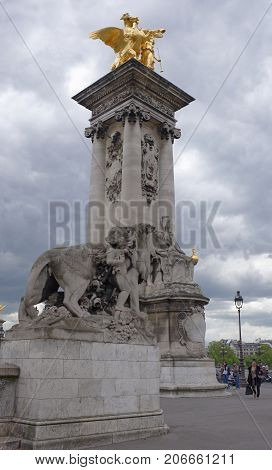 Paris; France- May 01; 2017: Renommee des Arts statue on the Pont Alexandre III Emmanuel Fremiet. People walk around and ride a motorcycle