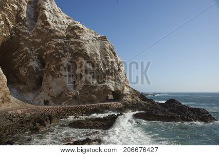 Anzota Caves at Arica on the coast of Chile. The area was used as a settlement by the Chinchorro people and later mined for guano deposited on the cliffs.