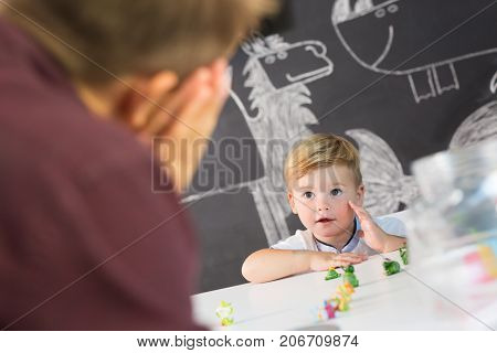 Cute little playfull toddler boy at child therapy session. Private one on one homeschooling with didactic aids.