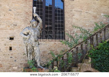 Grazzano Visconti Italy - August 07 2016: Old statue near stairs against stone wall