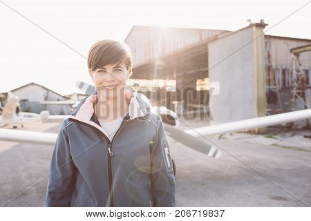 Smiling Woman At The Airport With Light Aircraft