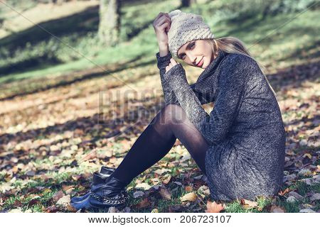 Young Blonde Woman Sitting In A Park With Autumn Colors
