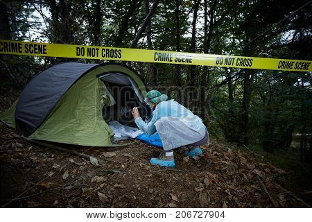 Forensics researcher photographing a blood  at a murder scene