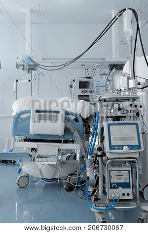 Hospital bed surrounded by a mass of medical equipment.