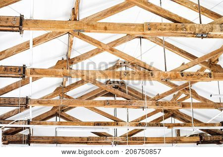 Wooden Roof Structure in White Bright Interior. Old Rafters in the Loft Interior