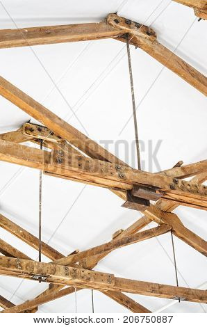 Wooden Roof Structure in White Bright Interior. Old Rafters in the Loft Interior