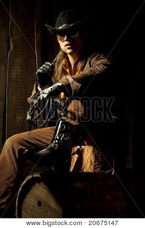 Cowboy with Black Leather Flogging Whip in his hand against wooden background