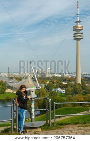 Lady tourist with backpack admiring the sights of Olympiapark on September 30 2017 in Munich Bavaria Germany.