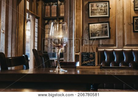 CAMBRIDGE, UK - SEPTEMBER 25, 2017: Interior of The Eagle Cambridge pub, empty wine glass on the table. Opened in 1667 as the 