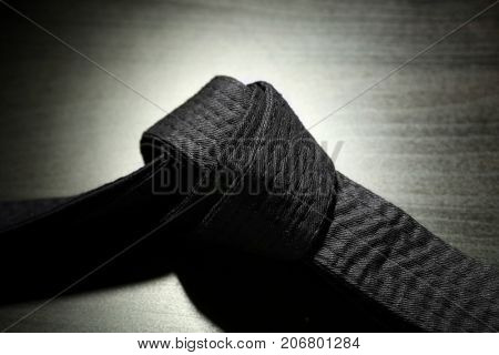 Black karate belt on dark background