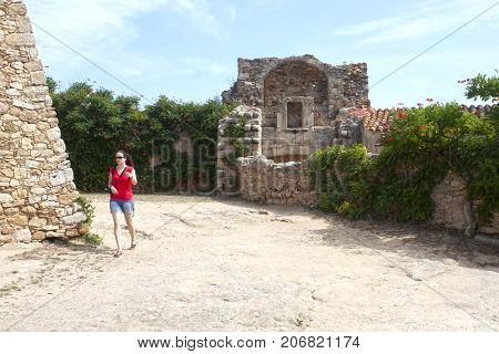 tourist girl visiting Peratallada in a sunny day, in Spain