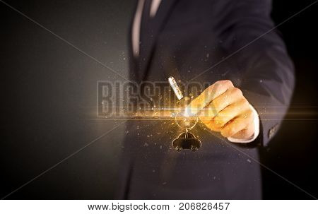 Businessman hand  over shiny keys in dark suit with dark background