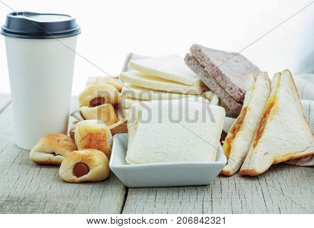 breads and coffee cups on wooden floor.