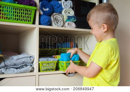 The Child Puts His Clothes On. The Boy Pulls The T-shirt Out Of The Closet.
