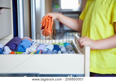 The Child Puts His Clothes On. The Boy Pulls The T-shirt Out Of The Closet.