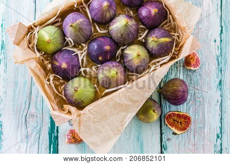 Fresh and ripe figs in a wooden box on the table.