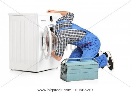 Um reparador tentando consertar uma máquina de lavar, isolada no fundo branco