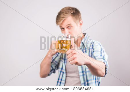 Man drinking beer. Happy young man holding a beer mug.
